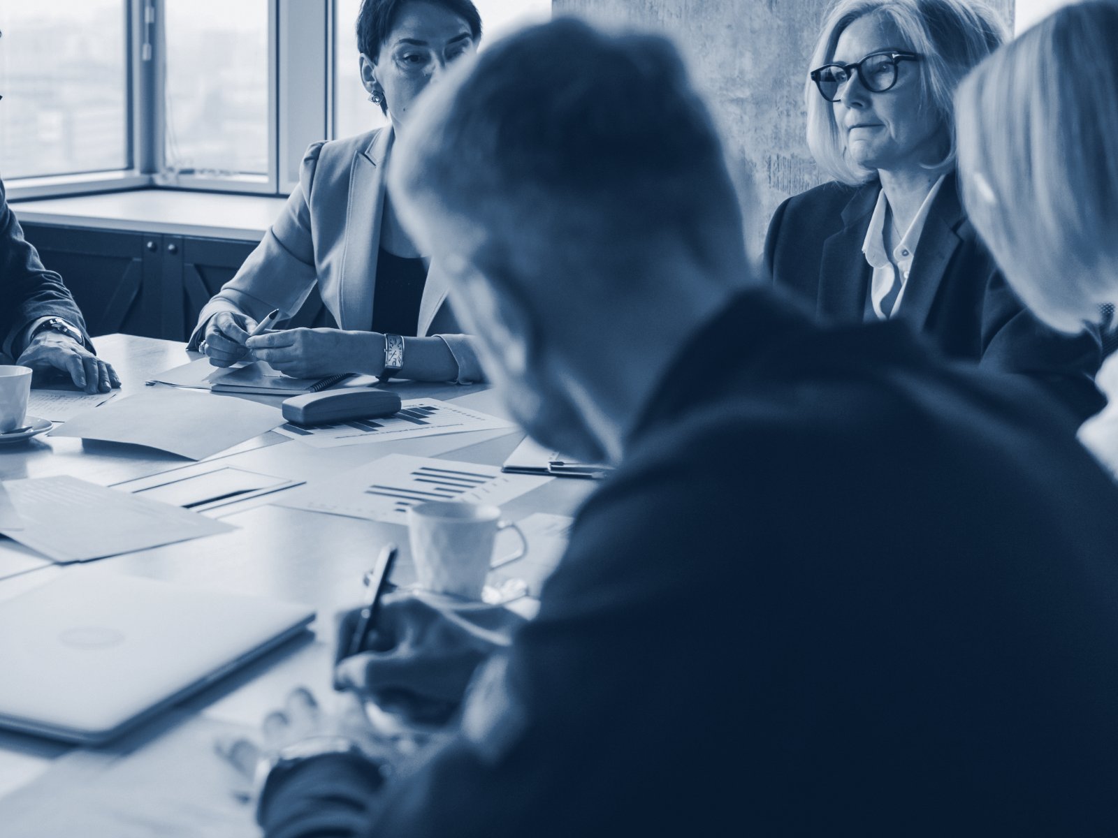 Advisory team reviewing documents and figures around a boardroom table