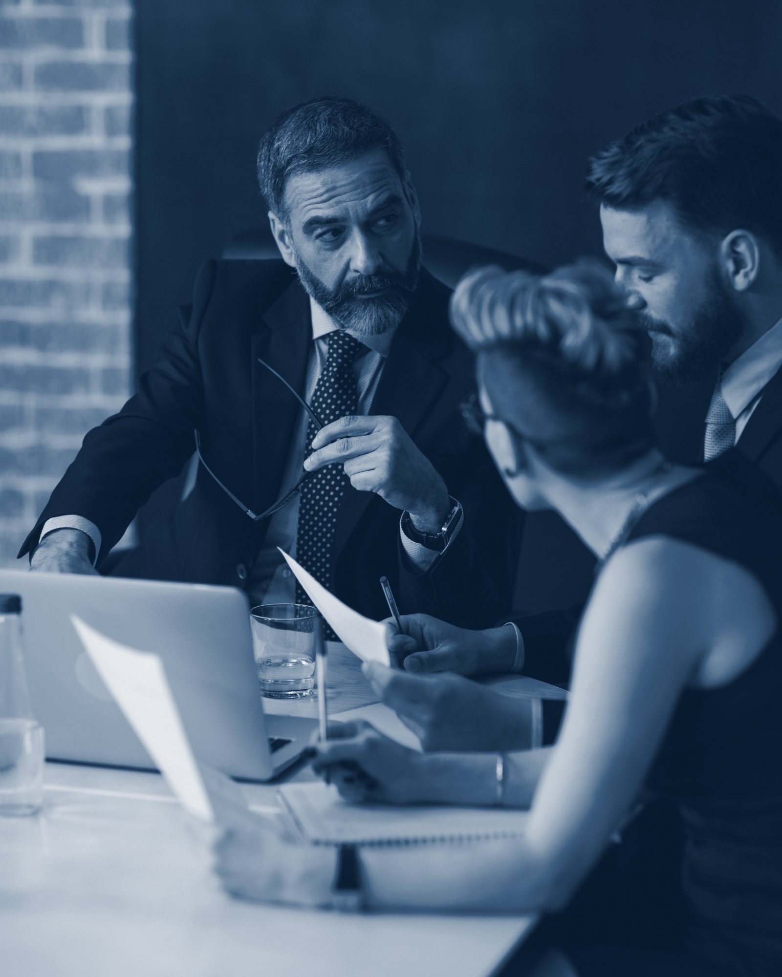 Senior adviser in discussion with colleagues at a meeting table